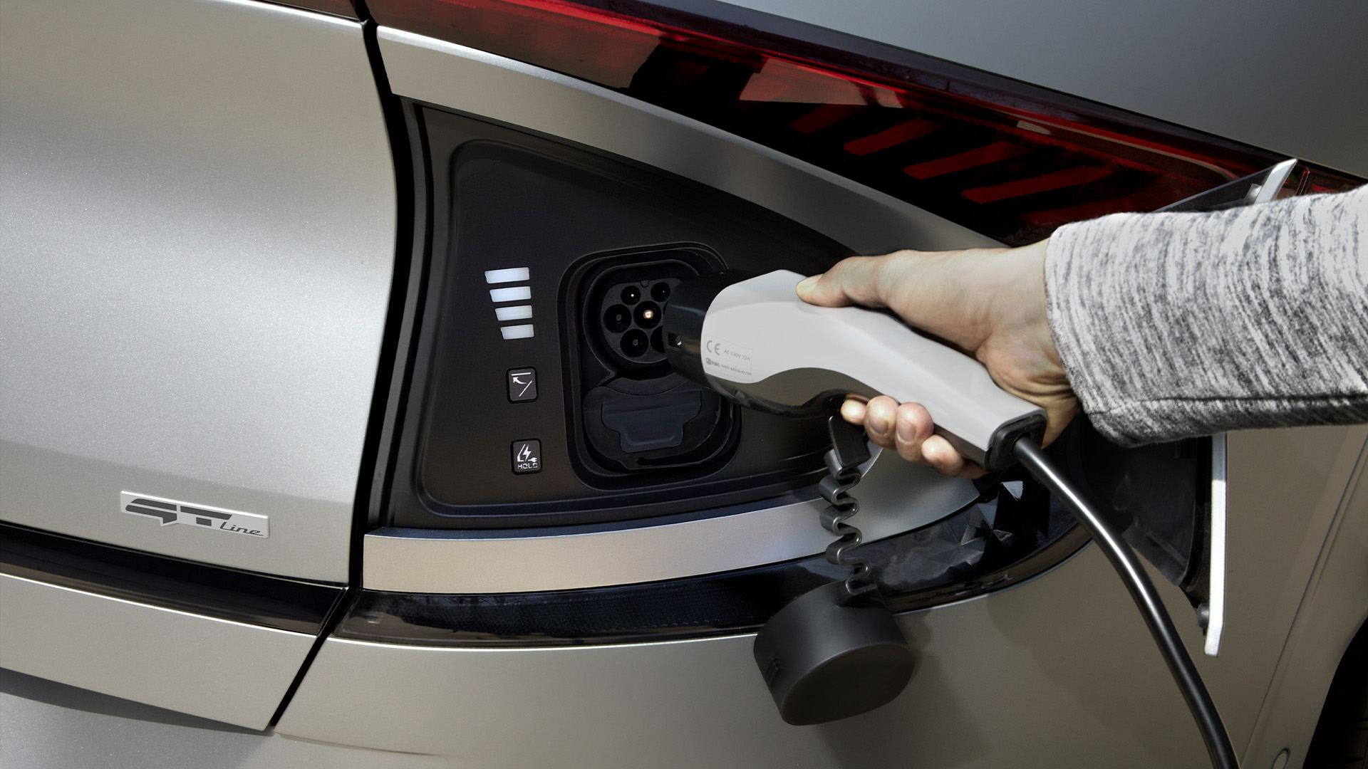 Close-up of a hand charging the EV6