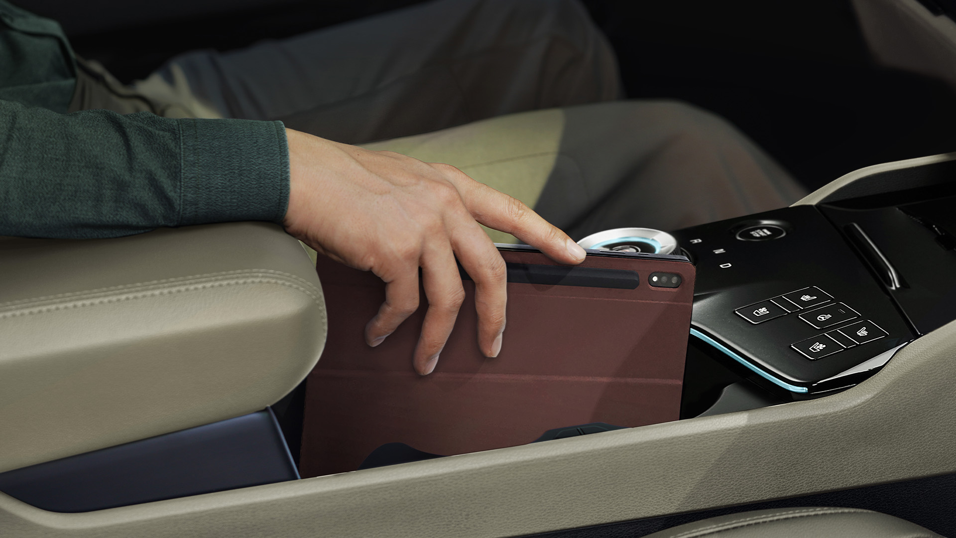 Hand of a man putting the tablet into the center console