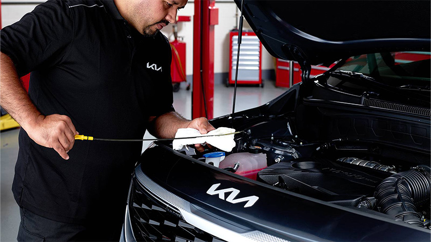 Mechanic inspecting a car with a long stick